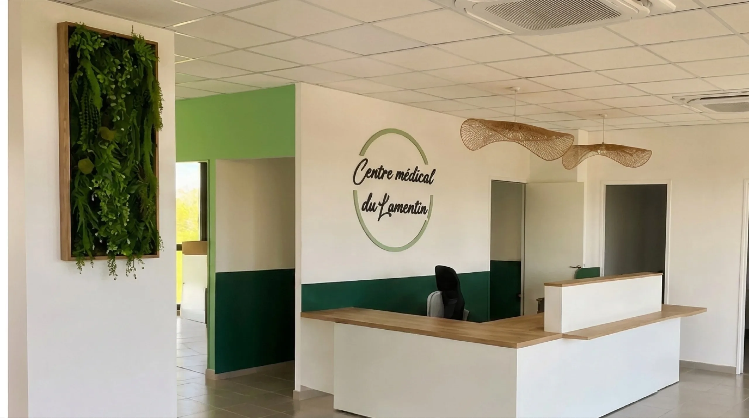 Le hall d'accueil chaleureux du Centre Médical du Lamentin, avec son mur végétal